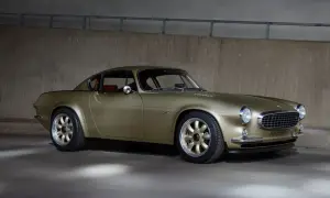 En gyllene Volvo P1800, en tidlös klassiker med en modern touch, står parkerad mot en betongvägg.