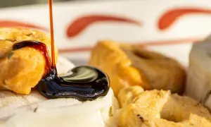 Une délicieuse entrée italienne : des taralli croustillants arrosés de glaçage balsamique sur un lit de fromage frais aux herbes.