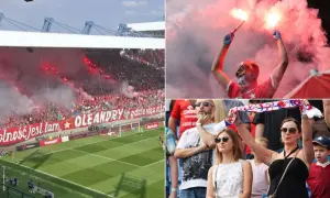 Kibice Wisły Kraków z racami i transparentem "Wolność jest tam, gdzie się nią żyje".