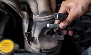 Mechanik wymienia czujnik tlenu w Volkswagenie, by naprawić błąd DTC P0420.