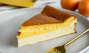Ein saftiges Stück Eierschecke auf einem grauen Teller, bereit zum Genuss. Dieses Eierschecke Rezept ist ein Klassiker.
