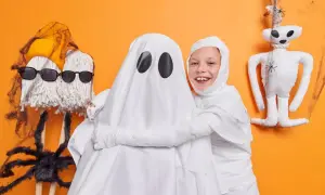 Dzieci w strojach duchów i mumii, idealne pomysły jak się przebrać na Halloween. Zabawne dekoracje i pajęczyny.
