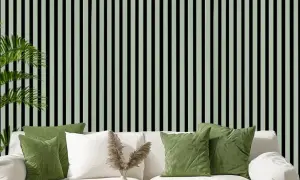Grüne Kissen auf weißem Sofa vor vertikal gestreifter Wand. Akustikpaneele verbessern den Raumklang und die Ästhetik.