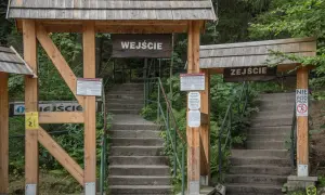 Kamienne schody prowadzą na trasę na Szczeliniec. Drewniane bramy z napisami "Wejście" i "Zeście" wyznaczają początek i koniec szlaku.