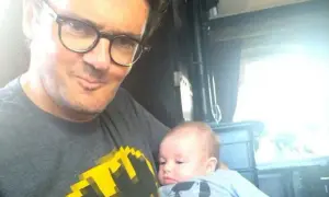 Kuba Wojewódzki z dzieckiem na rękach, w koszulce z Batmanem. Czy Kuba Wojewódzki ma dzieci? Tak, to dowód!
