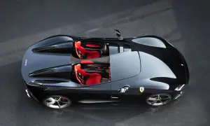 Czarny Ferrari Monza SP1 z czerwonymi siedzeniami, gotowy do jazdy po torze.