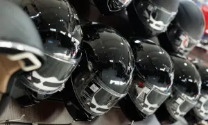 Błyszczące, czarne kaski motocyklowe na wystawie. Zastanawiasz się, jak dobrać kask motocyklowy? Wybierz idealny model dla siebie.