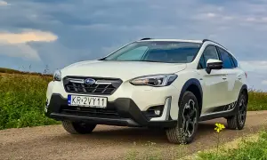 Biały Subaru XV na drodze polnej, z polami w tle. Rozważasz zakup? Sprawdź wady i zalety tego modelu.