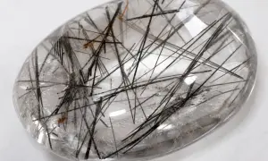 Cuarzo rutilado propiedades: piedra transparente con inclusiones negras y doradas, como un bosque de agujas.