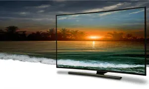 Zachód słońca na plaży z palmami, wyświetlany w jakości 4k full hd na zakrzywionym ekranie telewizora.