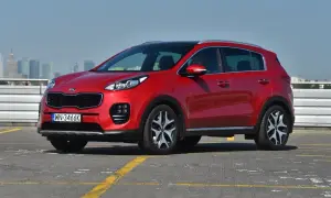 Czerwona Kia Sportage 2.0 diesel, z czarnym dachem, na parkingu. Zastanawiasz się, ile pali?