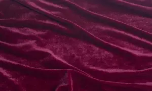 Głęboki, burgundowy rodzaj welwetu, miękko układający się w fałdy, odbijający światło.