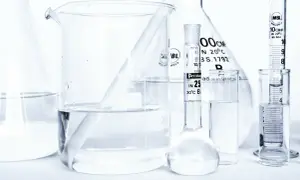 Laboratorium z kolbami i zlewkami, w których znajduje się płyn, być może butylene glycol, gotowy do analizy.
