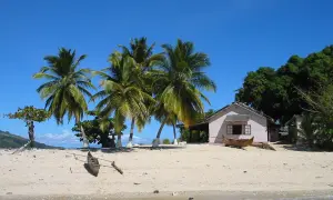 Piękna plaża z palmami, domkiem i łodzią. Zastanawiasz się, ile się leci na Madagaskar? To raj na ziemi!