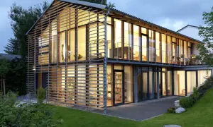 Modernes Haus mit Satteldach, das durch eine Glasfassade und horizontale Lamellen eine neue Interpretation erfährt.