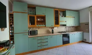 Cucina con ante azzurre e finiture in legno. Si pensa a come cambiare colore ante cucina per un look più moderno.
