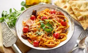 Pyszny makaron z chorizo, pomidorkami koktajlowymi i świeżą bazylią, posypany parmezanem. Idealny na szybki obiad.