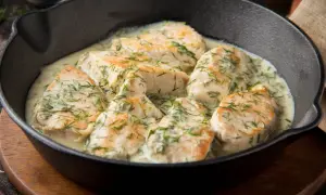 Aromatyczny kurczak w sosie śmietanowym z koperkiem, podany w żeliwnej patelni.