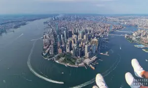 Widok z lotu ptaka na Manhattan, pełen drapaczy chmur, rzekę i mosty. Widać, w jakim stanie jest Nowy Jork – tętniący życiem, dynamiczny.