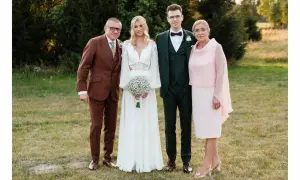 Rodzice i para młoda elegancko na ślub córki. Ojciec w brązowym garniturze, matka w różowej sukience.