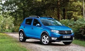 Niebieski Dacia Sandero Stepway na leśnej drodze, gotowy na przygodę.