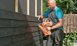 Man monterar liggande panel med spikpistol.