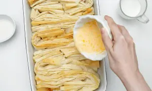 Przygotowanie ciasta filo. W miseczce ubite jajko, obok cukier i mleko. Czas na pyszne przepisy!