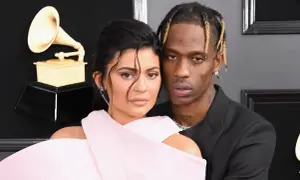 Kylie Jenner i Travis Scott na gali Grammy, blisko siebie, z Grammy w tle.