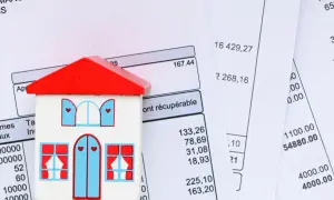 Maison en bois sur des factures. Apprenez comment calculer la taxe d'habitation.