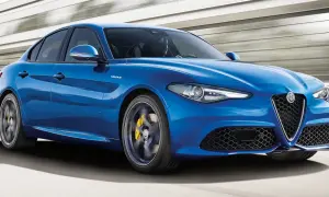 Błękitne Alfa Romeo Giulia Q4 Veloce w ruchu, z żółtymi zaciskami hamulcowymi i sportowym wyglądem.