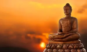 Buddha-staty i solnedgången. Lär dig fakta om buddhismen och dess symbolik.
