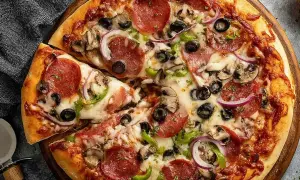 Pyszna pizza z pepperoni, oliwkami, pieczarkami i cebulą, idealna na szybki obiad. Ciasto na proszku do pieczenia sprawia, że jest puszyste i chrupiące.