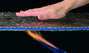 Dłoń nad materiałem, od spodu płomień. Mata aluthermo chroni przed ogniem.