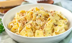 En skål med krämig citronpasta, toppad med pinjenötter och riven parmesan. En härlig rätt som passar perfekt för en snabb och smakrik middag.