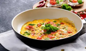 Pyszny omlet z pomidorami i ziołami na patelni, idealny na śniadanie w stylu dieta low carb.