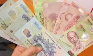 W ręce trzymam plik banknotów. To waluta Wietnamu, w tym banknoty 500 000 i 10 000 dongów.