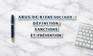 Lettres sur un fond marbre : "Abus de biens sociaux : définition, sanctions et prévention". Stylo et clavier à proximité.
