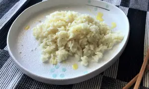 Piatto di riso in bianco, semplice e profumato, pronto per essere gustato con le bacchette.