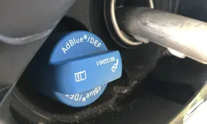 Niebieski korek wlewu AdBlue z napisem "AdBlue®/DEF" i symbolem ostrzegawczym. Sprawdź, ile adblue zostało.