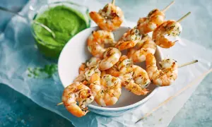 Gebratene Riesengarnelen auf Spießen, serviert mit einer grünen Sauce. Ein köstlicher Appetizer, der Lust auf mehr macht.