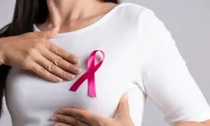 Kobieta z różową wstążką na piersi, symbolem walki z rakiem piersi. Leczenie tamoxifenem daje nadzieję.
