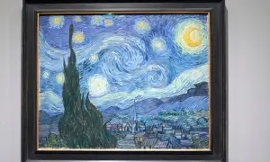 Van Gogh's blaues Bild zeigt einen wirbelnden Sternenhimmel über einem Dorf. Zypressen ragen empor, Sterne leuchten, der Mond strahlt.
