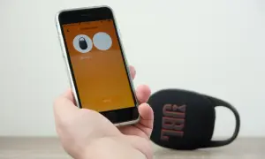 Sprawdzanie, czy słuchawki bezprzewodowe JBL działają z iPhone. Na ekranie telefonu widać aplikację do tworzenia stereo z głośnikiem JBL Clip 5.