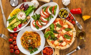 Italienische Pasta Vorspeisen: Tagliatelle Bolognese, Pizza Margherita, Caprese-Salat, Gemüsesticks mit Dip und Oliven. Ein Festmahl!