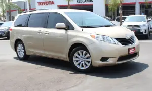 Złoty minivan Toyota Sienna 2025 na tle salonu Toyota.