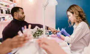 Mann lässt sich im Nagelstudio die Nägel machen. Ein Kleingewerbe wie dieses unterliegt der IHK-Pflicht.