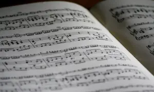Otwarta księga nut, z nutami i znakami muzycznymi. Widać fragmenty z dynamiką, sugerujące glissando w muzyce.