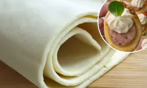 Ciasto francuskie zwinięte w rolkę i małe przekąski z kiełbasą w cieście francuskim.