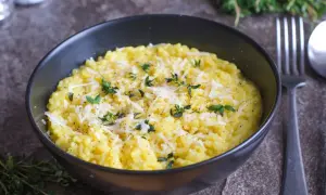 En krämig risotto alla milanese, toppad med riven parmesan och färska örter.