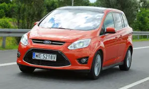 Pomarańczowy Ford C-Max na drodze. Wiele osób szuka ford c max opinie przed zakupem.